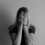 woman covering face with her hands