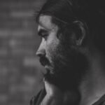 Man with beard and long hair looking away