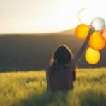 unknown person holding balloons outdoors