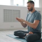 Man meditating in a bright, minimalist room.